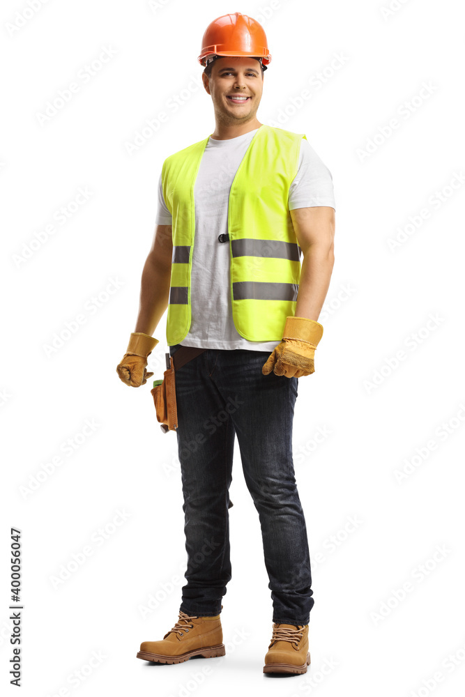 Smiling young construction worker with a helmet and tool belt Smiling young construction worker with a helmet and tool belt
