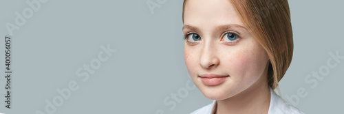Pretty young girl portrait at studio. Blue eyes kid. Grey background. Thoughtful emotion. Pupil homework. Creative person. Little child model. Looking camera. Beauty face. Female headshot. Copyspace