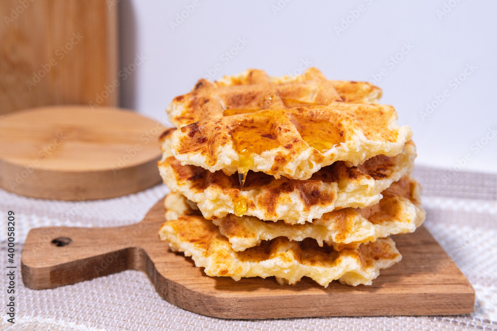 Waffles with honey close-up. Healthy breakfast. Honey pouring on a fresh Belgian waffles. Waffles with honey close-up. Healthy breakfast. Honey pouring on a fresh Belgian waffles.