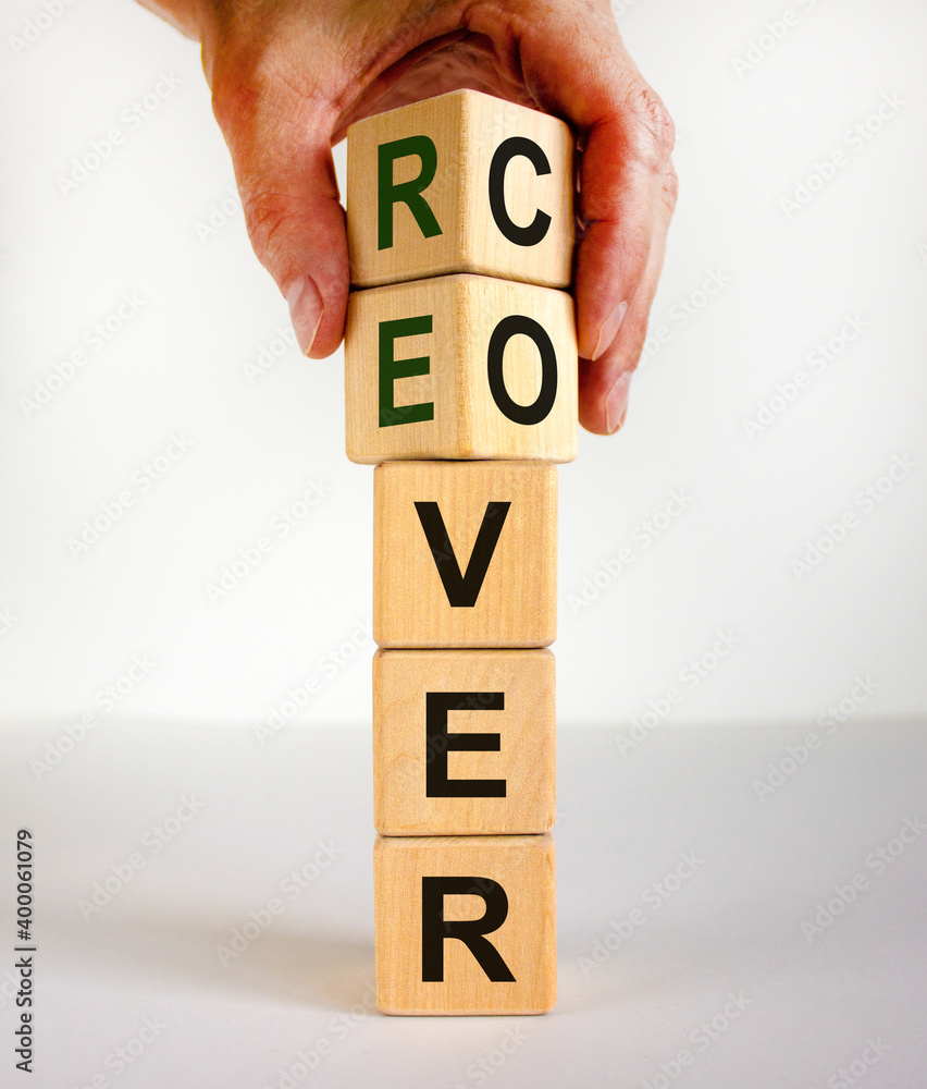 Time to recover symbol. The word 'recover' on wooden cubes. Male hand. Beautiful white background, copy space. Business and recover concept. Time to recover symbol. The word 'recover' on wooden cubes. Male hand. Beautiful white background, copy space. Business and recover concept.