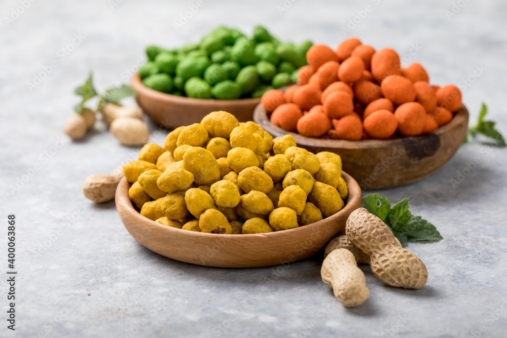 Assortment of different peanuts snack for beer, wine, party bar. Salted peanuts, green vasabi, red spicy chilli, yellow cheese glaze Assortment of different peanuts snack for beer, wine, party bar. Salted peanuts, green vasabi, red spicy chilli, yellow cheese glaze
