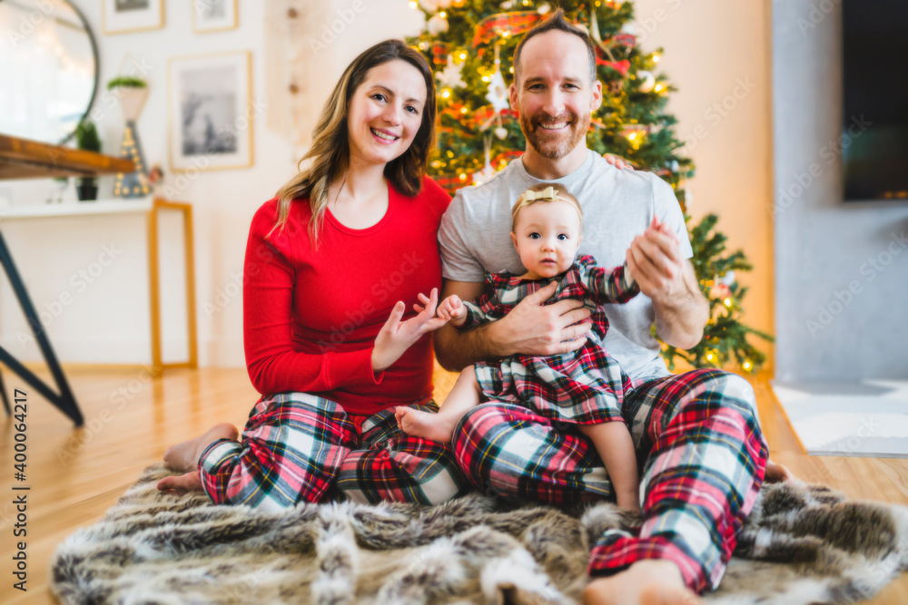 Fototapeta premium Christmas family with baby close to a tree
