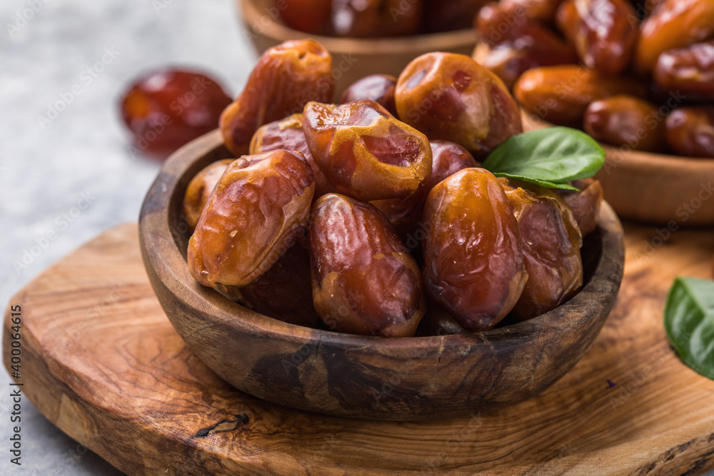 Dates or dattes palm fruit in wooden bowl is snack healthy.Creative layout made of dried dates. Flat lay. Food concept. Fruits dates. Dates Palm fruit isolated on white. Dried fruits. Healthy diet. Dates or dattes palm fruit in wooden bowl is snack healthy.Creative layout made of dried dates. Flat lay. Food concept. Fruits dates. Dates Palm fruit isolated on white. Dried fruits. Healthy diet.