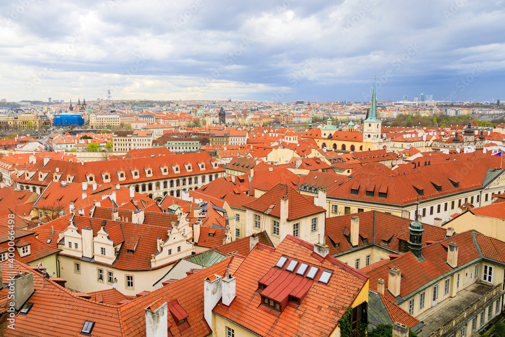 Obraz premium Red-brown roofs of beautiful cities made of natural tiles. The view from the top. in the distance, the horizon of the blue sky.