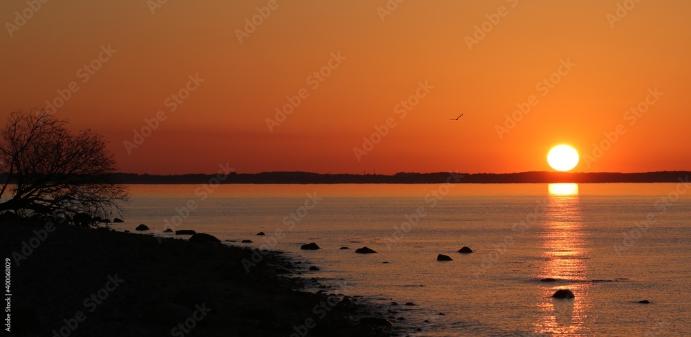 Stunning seascape with bright red evening sky at sunset.