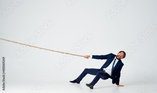man with rope in hand on light background business finance 