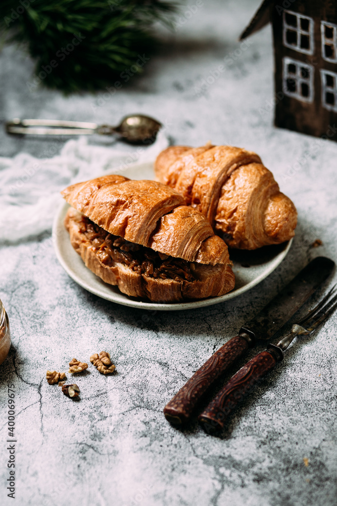 Croissant with caramel and walnuts.Christmas dish on gray background