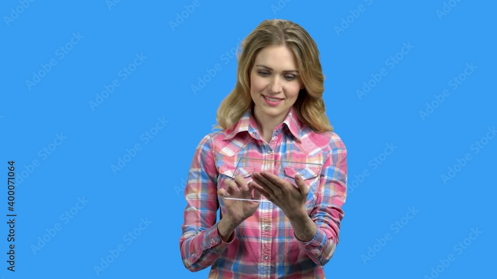 Young pretty woman using glass digital tablet. Beautiful girl using futuristic transparent tablet pc on color background. Young pretty woman using glass digital tablet. Beautiful girl using futuristic transparent tablet pc on color background.