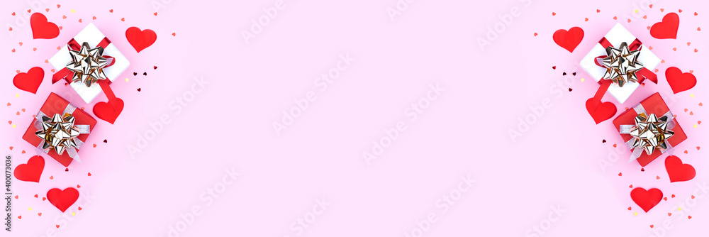 Background with gift, hearts and confetti with free space for text on pastel pink background, wide angle view. Flat lay, top view. Valentines day concept. Mother's Day concept. Banner.