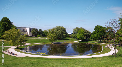 A park where people meet at a pond in the Bürgerpark Bielefeld at the Rudolf Oetker Halle