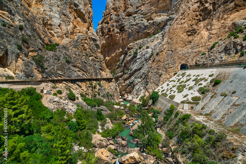 Obraz na płótnie Paisaje de un desfiladero con un rio, un camino de montaña y una vía férrea con un túnel