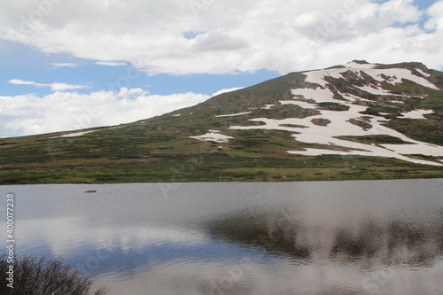 mountain above lake with melting snow