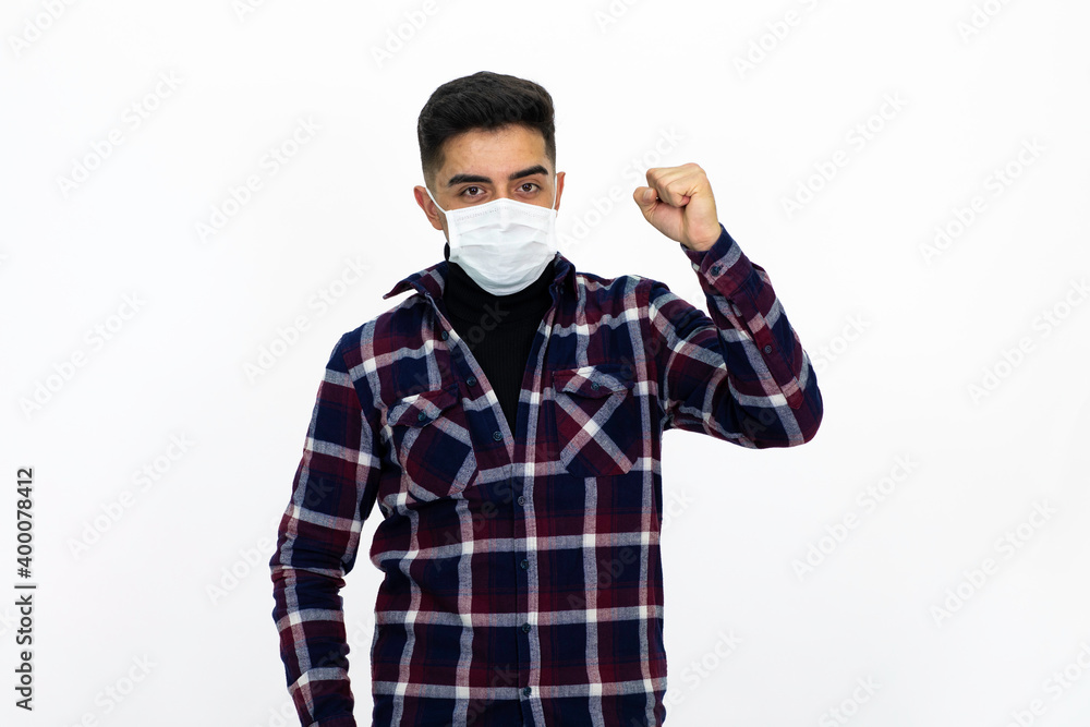Handsome young man male model. He is wearing a medical mask and a dark checkered shirt. Handsome young man male model. He is wearing a medical mask and a dark checkered shirt.