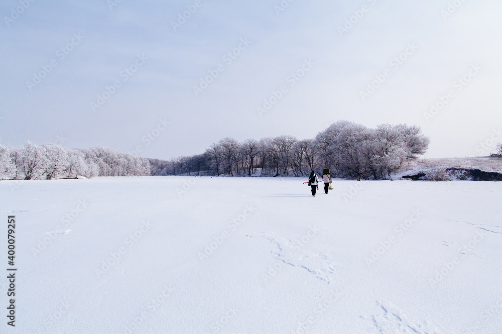 winter fishermen on frozen snowy lake