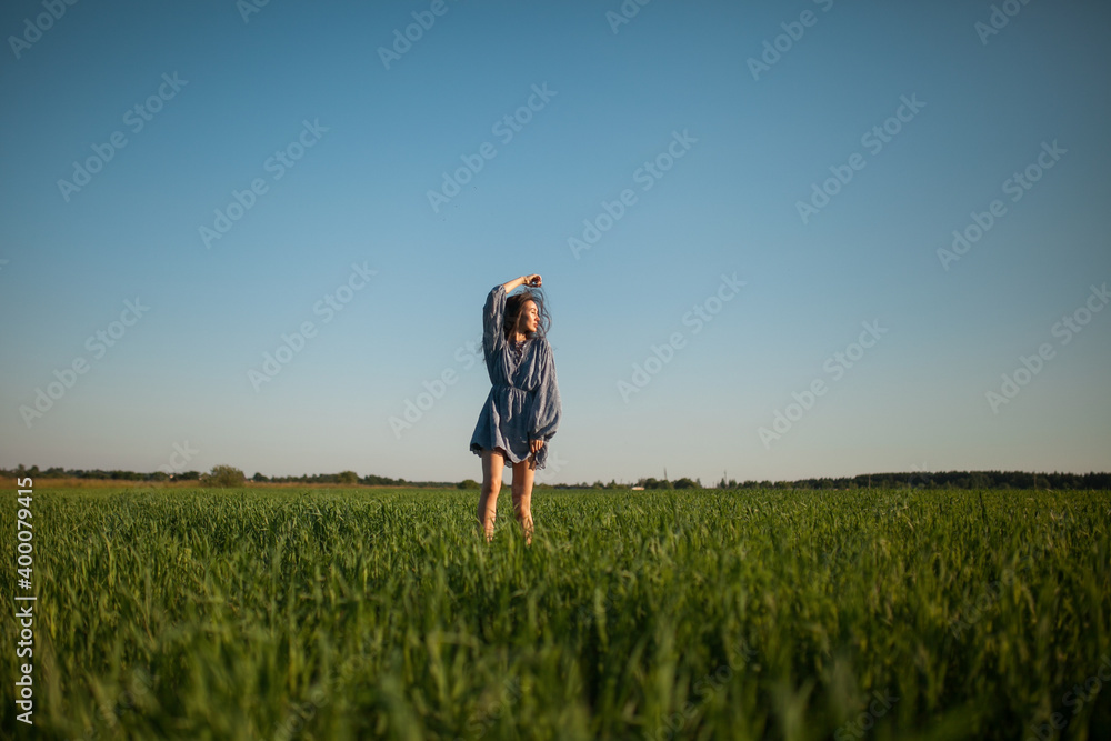 The girl walks in the field in summer. The girl walks in the field in summer.