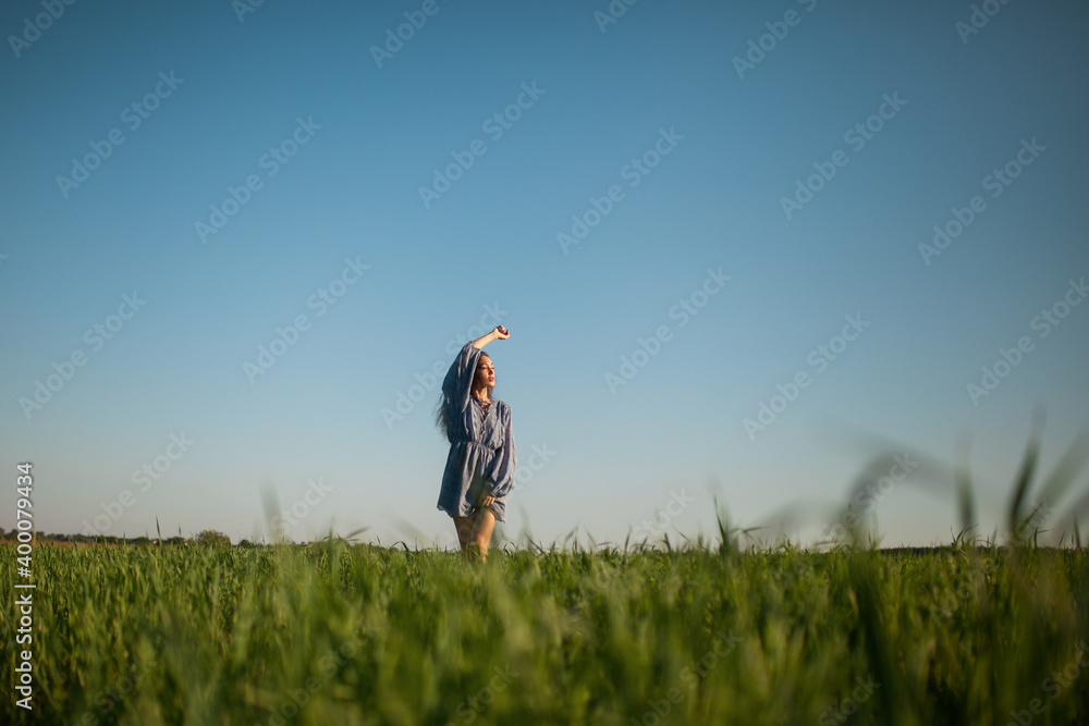 The girl walks in the field in summer. The girl walks in the field in summer.