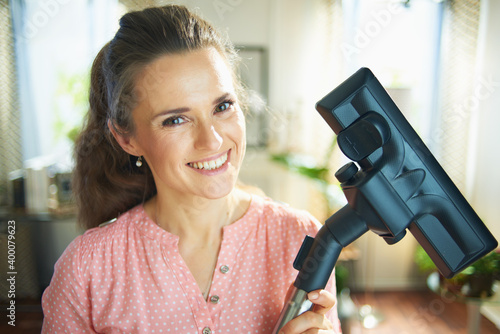 happy young 40 years old woman with vacuum cleaner brush photo