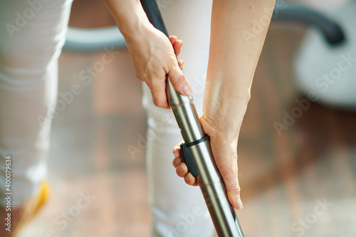 woman with vacuum cleaner brush at home in sunny day