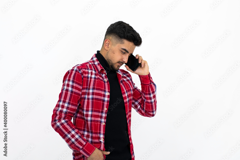 Teenager speaking by phone, wearing a red checkered shirt. Teenager speaking by phone, wearing a red checkered shirt.