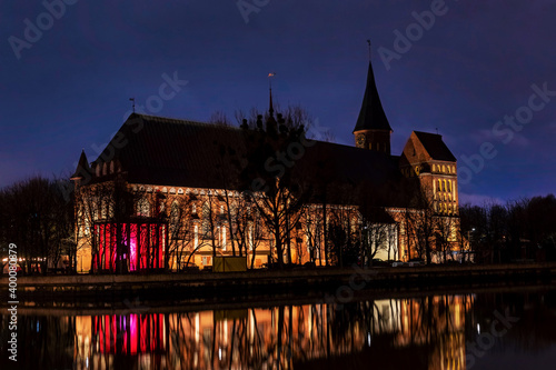 Brick Gothic style Cathedral at night, side view from the river. Formerly old German Konigsberg Cathedral, Kaliningrad, Russia