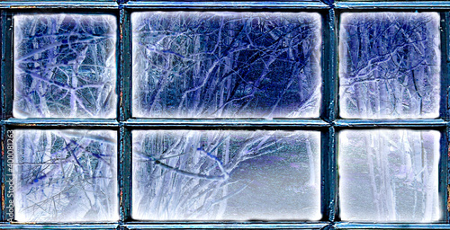 Frosted window frame with view at snowy trees. Winter background. 
