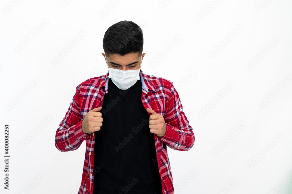 Young man wearing a medical mask. He wears a striped red shirt. Young man wearing a medical mask. He wears a striped red shirt.
