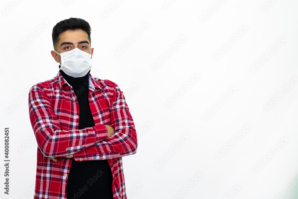 Young man wearing a medical mask. He wears a striped red shirt. Young man wearing a medical mask. He wears a striped red shirt.