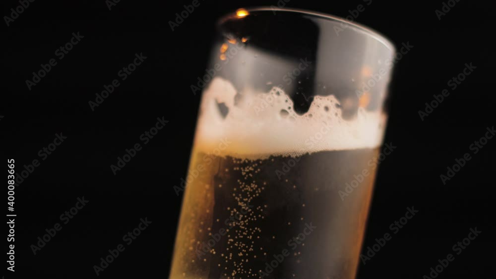 Glass of Cold Beer in Glass, Close Up Spinning, Isolated on Black Background Glass of Cold Beer in Glass, Close Up Spinning, Isolated on Black Background