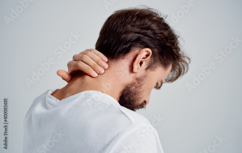 man touching his neck with his hand osteochondrosis back pain