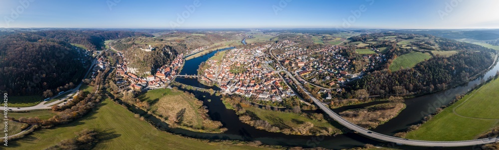 Bild einer Panorama Luftaufnahme mit einer Drohne der Stadtansicht des Markt Kallmünz Kallmuenz in Bayern und der Brücke über den Fluss Naab und Vils und der Burg Ruine auf dem Berg, Deutschland