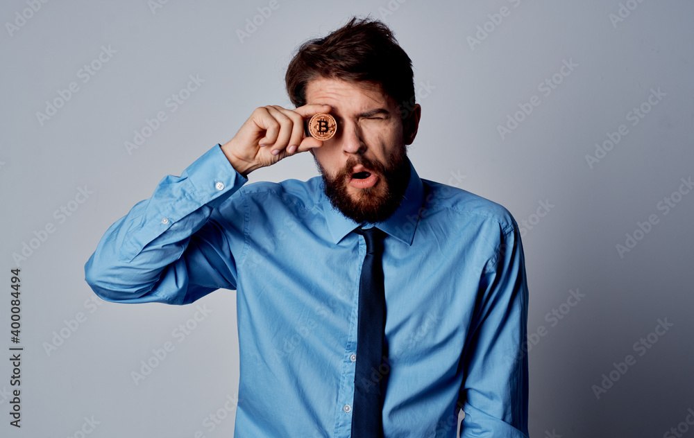 Business man in a blue shirt with a coin in his hands Bitcoin Business man in a blue shirt with a coin in his hands Bitcoin