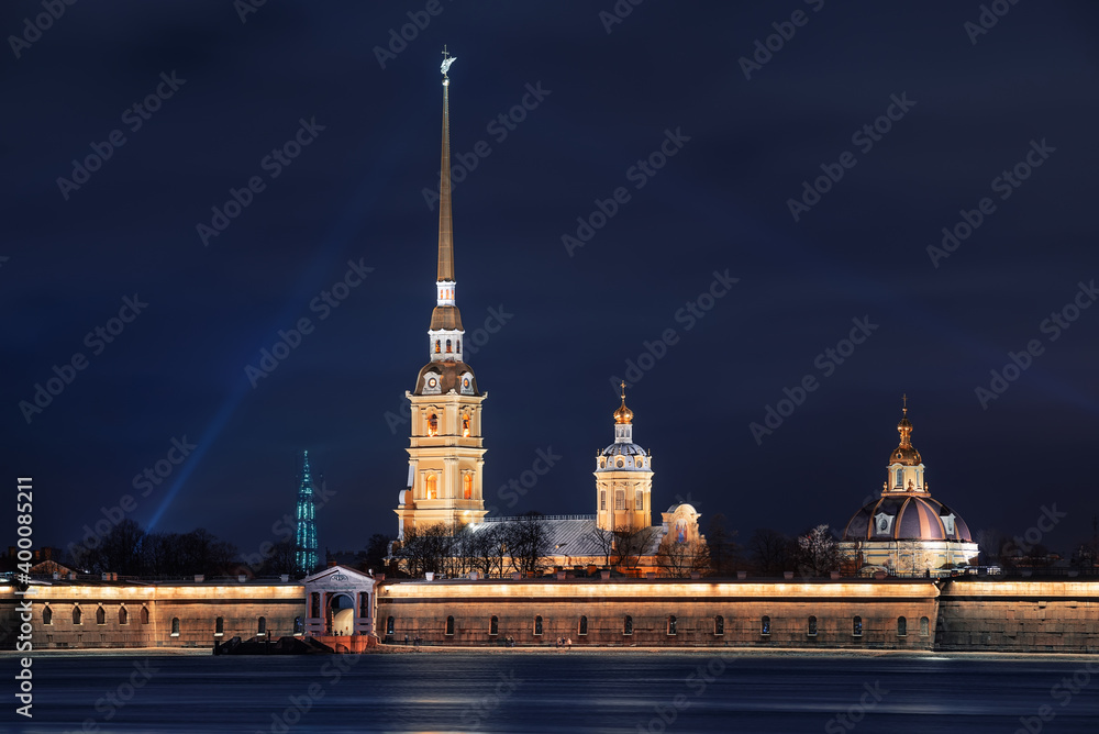 Beautiful night view from the embankment of the Neva River to the Peter and Paul Fortress, located on Zayachy Island. The bell tower of the Peter and Paul Cathedral. Saint Petersburg, Russia.