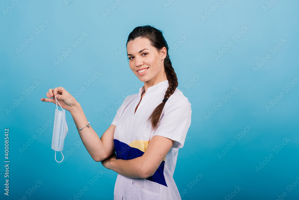 Portrait of female doctor in medical mask looking away isolated on blue Portrait of female doctor in medical mask looking away isolated on blue