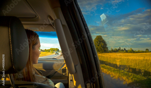 woman looking through car window during sunset