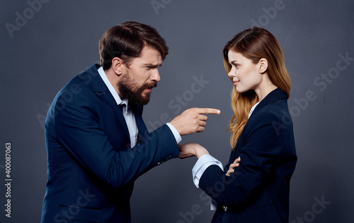 Business man and woman in suit gesturing with hands on gray background cropped view