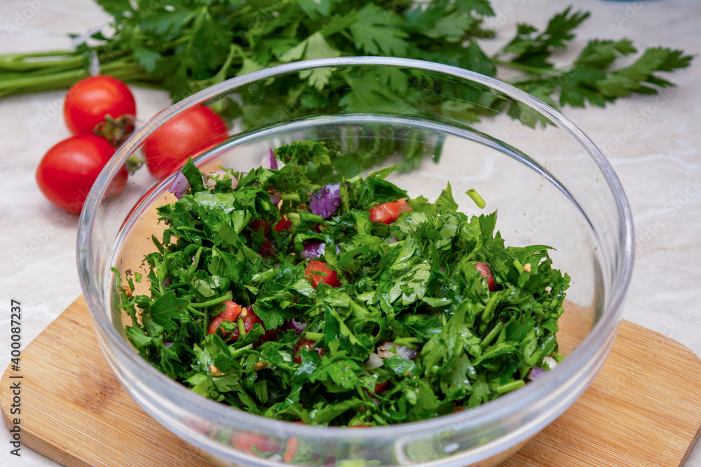 Close up on Tabbouleh salad made with parsley, cherry tomatoes, onion, lemon, olive oil and basil Close up on Tabbouleh salad made with parsley, cherry tomatoes, onion, lemon, olive oil and basil