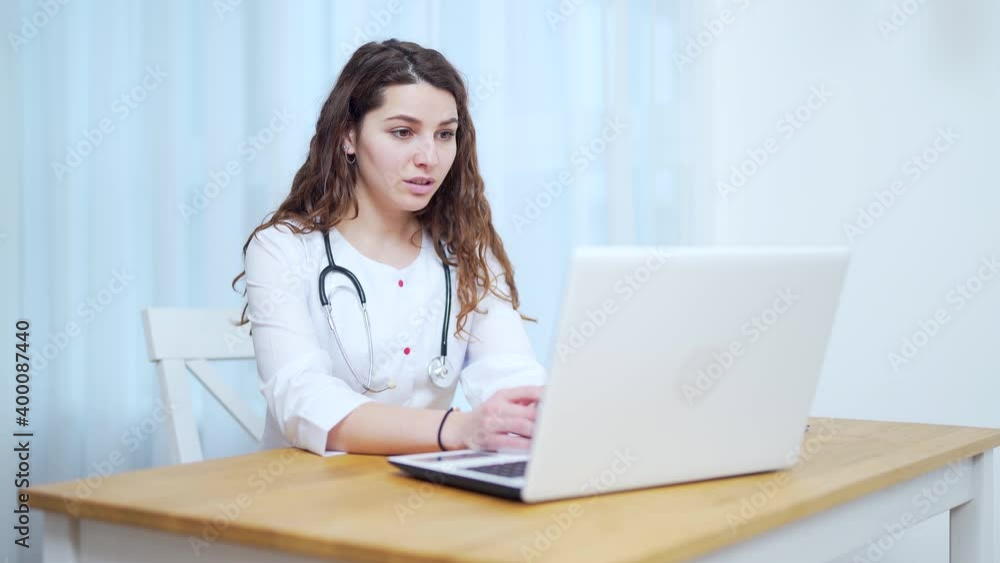 Woman doctor talking to client using virtual chat computer app. Female medical assistant wears white coat, video calling distant patient on laptop. Telemedicine, online remote healthcare services Woman doctor talking to client using virtual chat computer app. Female medical assistant wears white coat, video calling distant patient on laptop. Telemedicine, online remote healthcare services