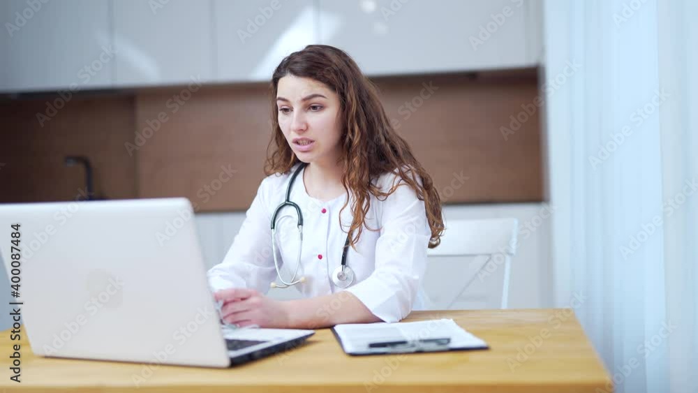 Woman doctor talking to client using virtual chat computer app. Female medical assistant wears white coat, video calling distant patient on laptop. Telemedicine, online remote healthcare services Woman doctor talking to client using virtual chat computer app. Female medical assistant wears white coat, video calling distant patient on laptop. Telemedicine, online remote healthcare services