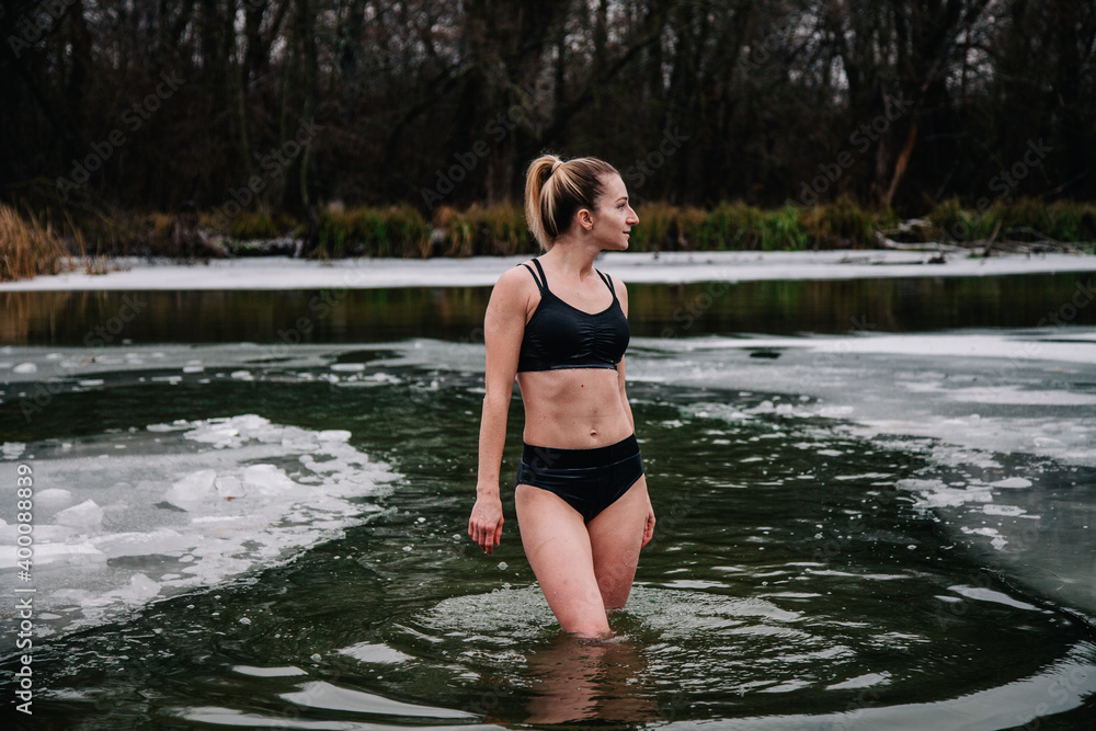 Young slender girl bathes in winter in a river hole Young slender girl bathes in winter in a river hole