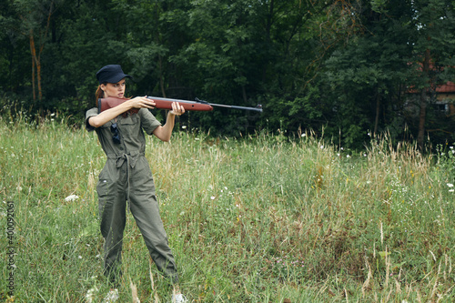 Woman soldier Holds a gun in the hands of a target side view black cap 