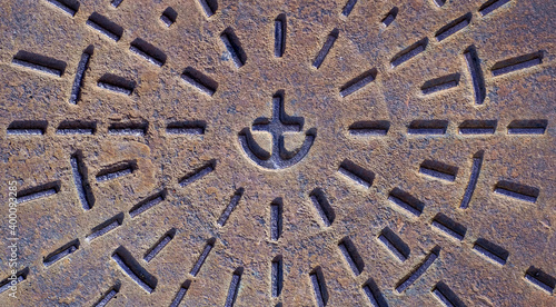 Anchor symbol cast in rusting metal surface, cast iron commercial grade decorated hardware, part of big town infrastructure.