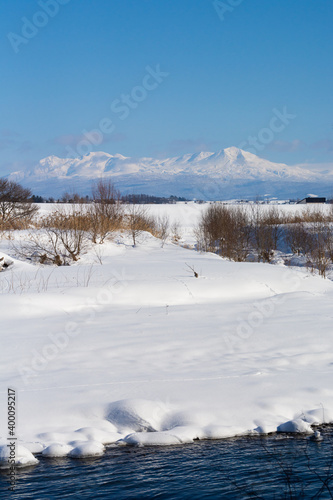 冬の河原と雪山と青空　大雪山  © kinpouge