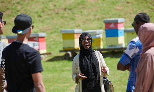 woman giving presentation to group of business investors on local honey production farm