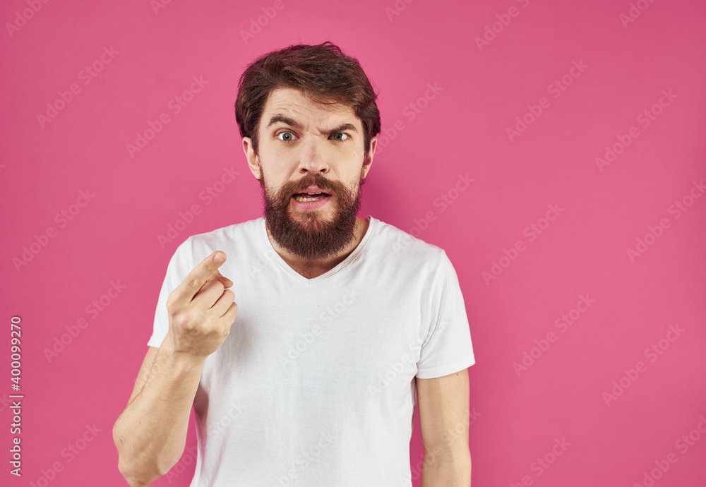 Irritated male gesturing with his hands on a pink background cropped view Irritated male gesturing with his hands on a pink background cropped view