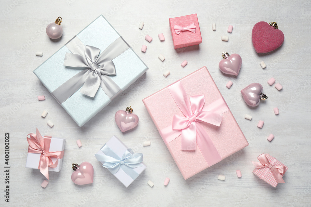 Beautiful gift boxes and festive decor on white table, flat lay Beautiful gift boxes and festive decor on white table, flat lay