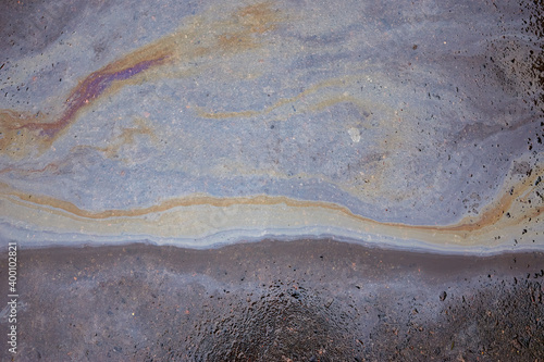 of the gasoline stain on the pavement road as a texture or background