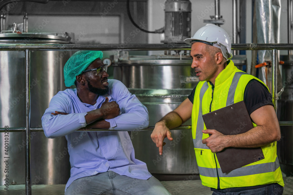 food factory engineer and worker talking together in food processng room food factory engineer and worker talking together in food processng room