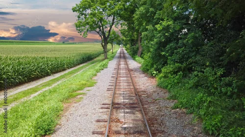 View From the Back of a Train as it Travels along Track Thru Countryside on a Sunny Summer Day
View From the Back of a Train as it Travels along Track Thru Countryside on a Sunny Summer Day
