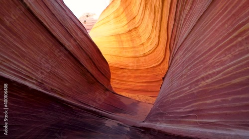 Camera gliding through The Wave sandstone structure in Arizona desert. Delicate sandstone carved by thousands of years of wind erosion. Unique geological formation and hiking trail near Knab Utah. photo