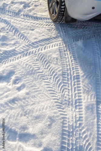 Car tire tracks in the snow close-up.